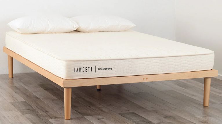 bed with light wood frame, white mattress, and two pillows