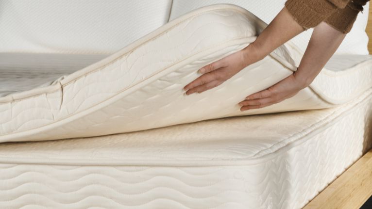 Hands adjusting mattress layers