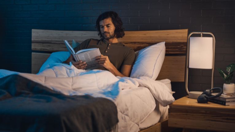 Man reading in bed at night