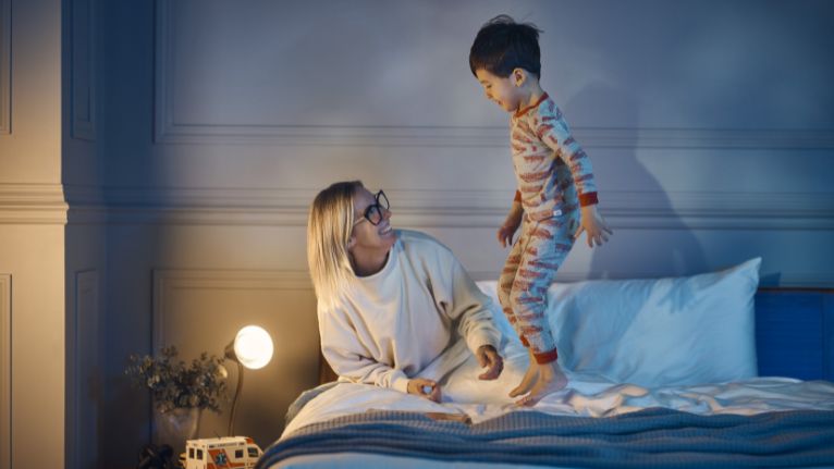Mother and a Child Playing on a Bed