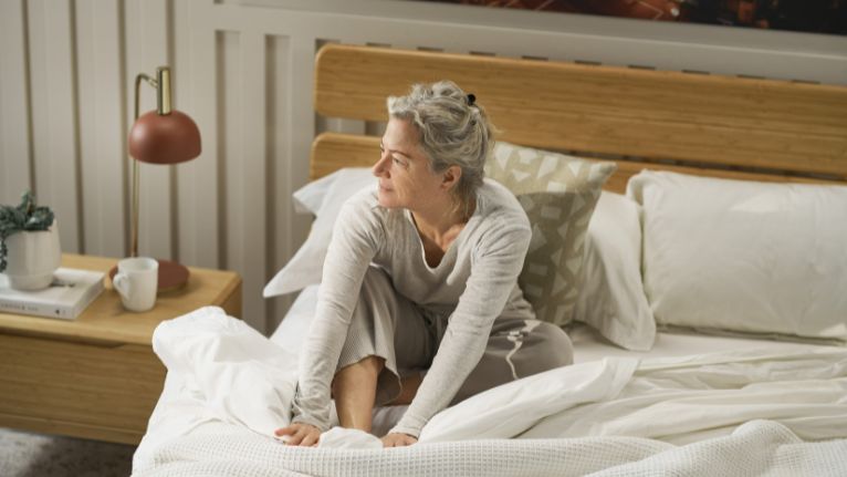 Older woman waking up in a cozy bedroom